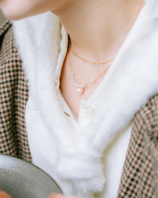 Person wearing a necklace with a blurred background