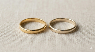 18K gold ring and 14K gold ring on a beige fabric background