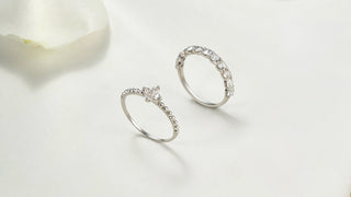 Two silver rings with gemstones on a light background