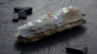 Mineral specimen with embedded diamonds on a dark surface